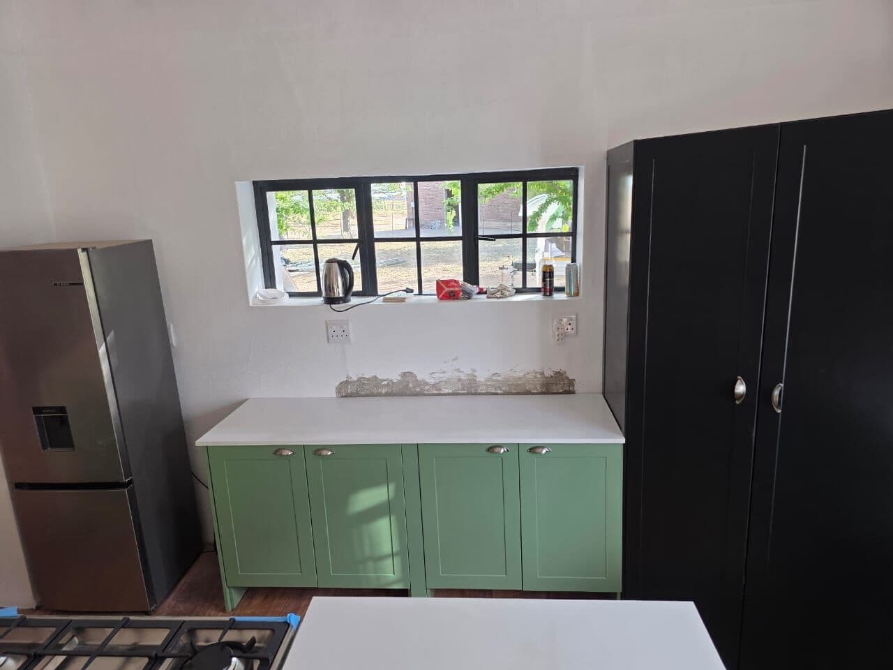 Black drawer units with oak top and glass cabinets